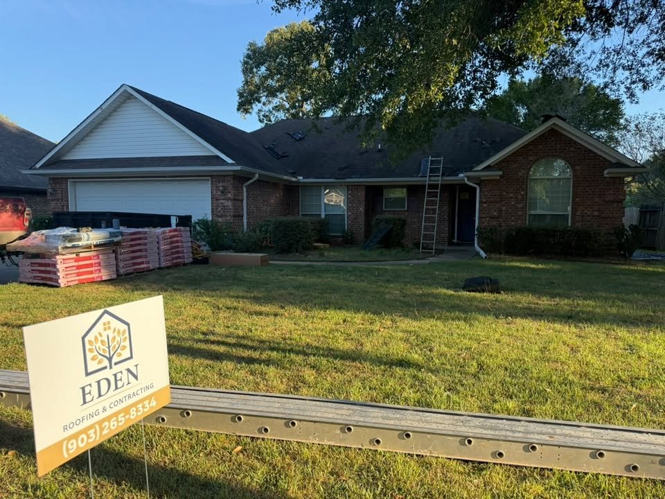 Before: the same brick home with its old, worn dark roof and shingles staged for replacement